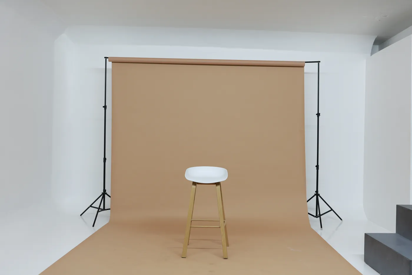 Sand seamless backdrop and stool set up on the white shooting floor