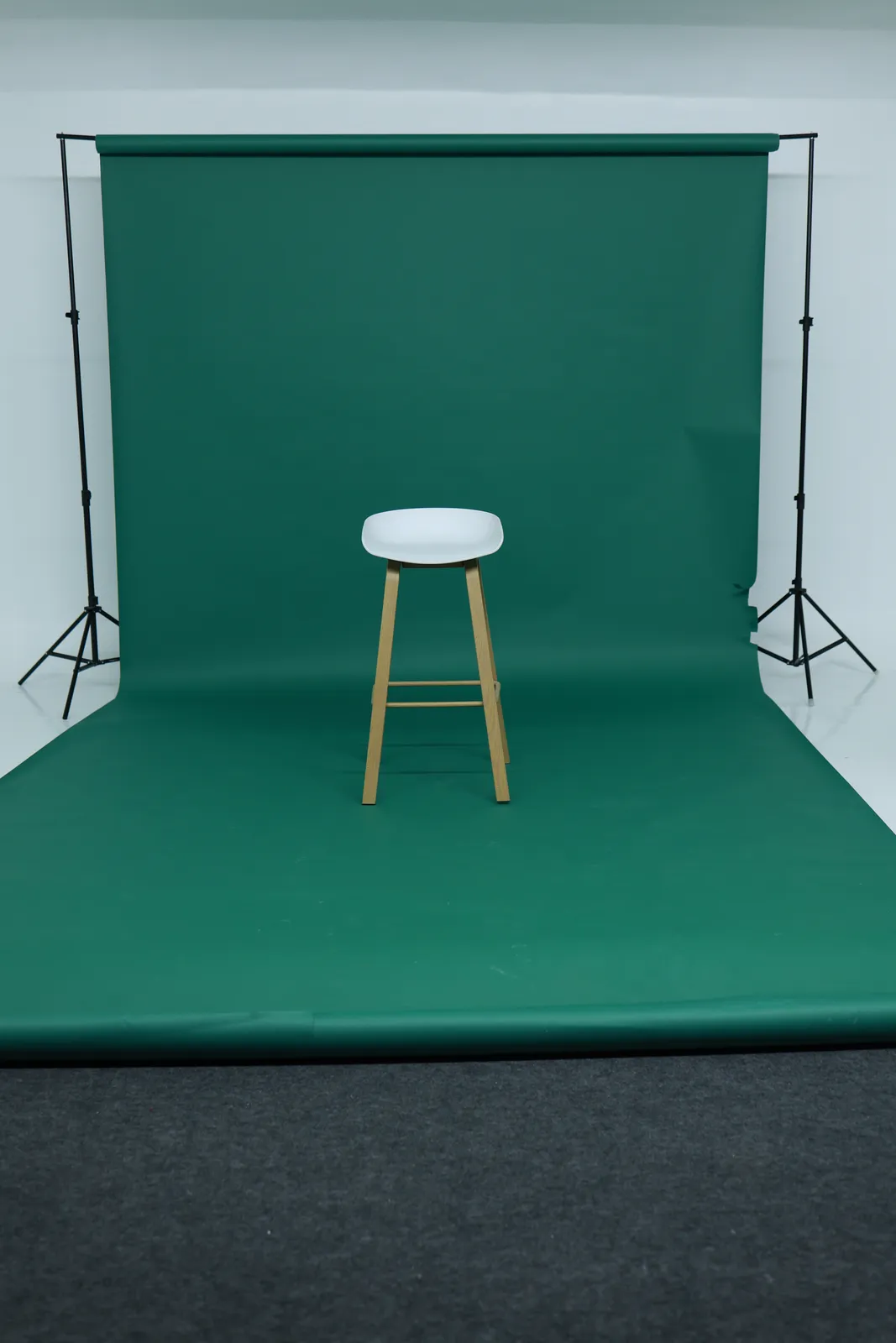 Deep forest green seamless paper installed across the studio wall and floor.