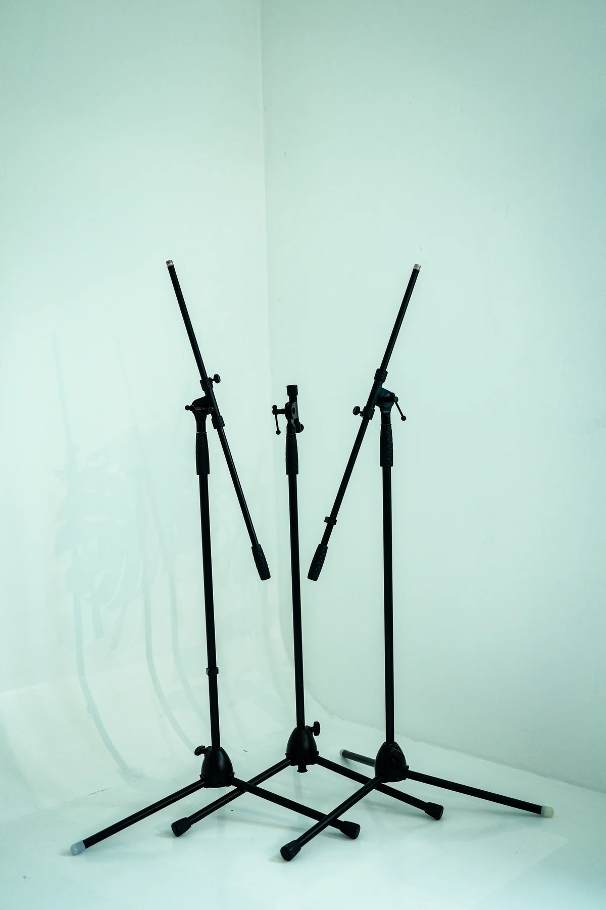 Two studio stands photographed against the seamless white wall.